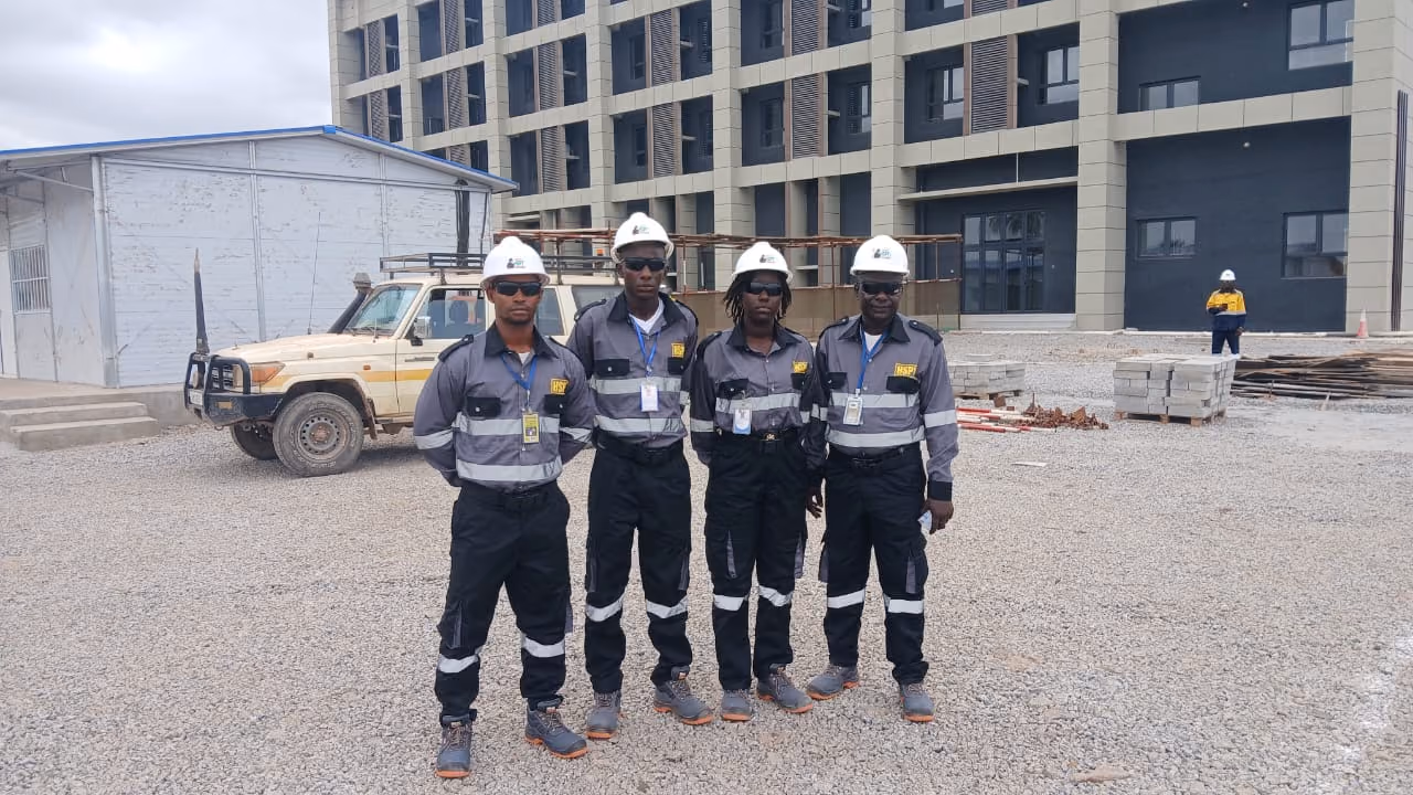 Agents GROUPE HSPT casqués devant un bâtiment en construction